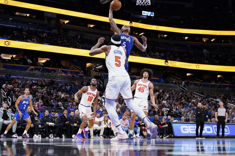 ORLANDO, FLORIDA - FEBRUARY 14: Paolo Banchero #5 of the Orlando Magic dunks the ball over Precious Achiuwa #5 of the New York Knicks during the fourth quarter at Kia Center on February 14, 2024 in Orlando, Florida. NOTE TO USER: User expressly acknowledges and agrees that, by downloading and or using this photograph, user is consenting to the terms and conditions of the Getty Images License Agreement. (Photo by Rich Storry/Getty Images)