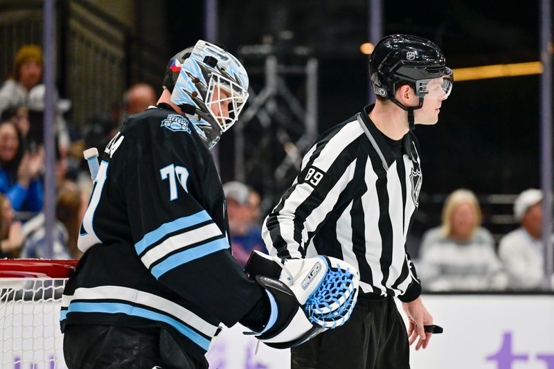 Nov 29, 2024; Salt Lake City, Utah, USA; linesman Joseph Mahon (89) retrieves the puck from Utah Hockey Club goaltender Karel Vejmelka (70) after a block against the Edmonton Oilers during the third period at the Delta Center. Mandatory Credit: Christopher Creveling-Imagn Images