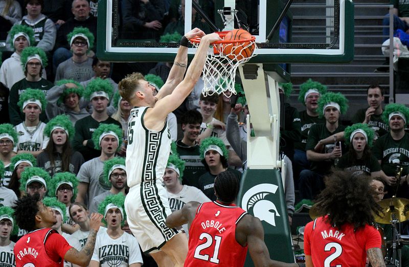Mar 5, 2026; East Lansing, Michigan, USA;  Michigan State Spartans center Carson Cooper (15) dunks the ball past the Rutgers Scarlet Knights defense during the first half at Jack Breslin Student Events Center. Mandatory Credit: Dale Young-Imagn Images