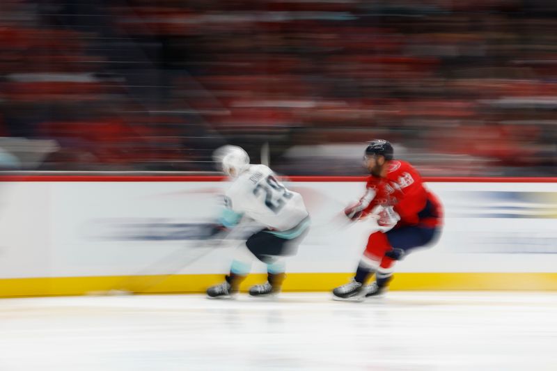 Oct 21, 2025; Washington, District of Columbia, USA; Seattle Kraken defenseman Vince Dunn (29) and Washington Capitals right wing Tom Wilson (43) chase a puck during the third period at Capital One Arena. Mandatory Credit: Geoff Burke-Imagn Images