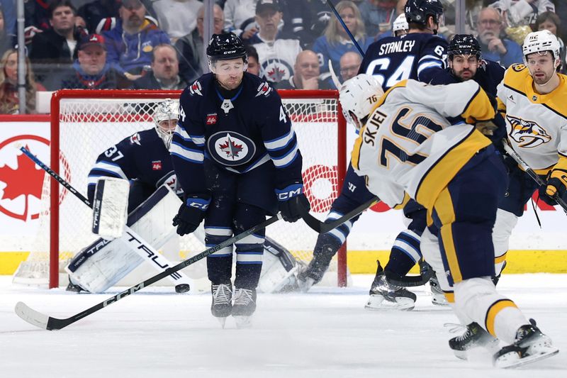 Jan 7, 2025; Winnipeg, Manitoba, CAN; Winnipeg Jets defenseman Neal Pionk (4) blocks a shot by Nashville Predators defenseman Brady Skjei (76) in the second period at Canada Life Centre. Mandatory Credit: James Carey Lauder-Imagn Images