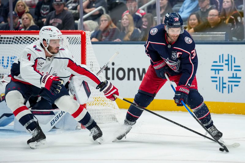 Sep 30, 2025; Columbus, Ohio, USA; Columbus Blue Jackets center Boone Jenner (38) skates with the puck against Washington Capitals defenseman Matt Roy (3) in the third period at Nationwide Arena. Mandatory Credit: Aaron Doster-Imagn Images