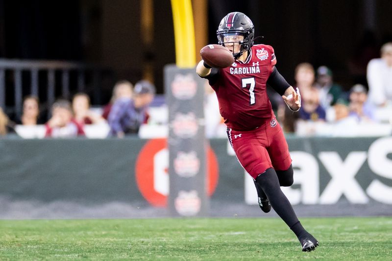 Dec 30, 2022; Jacksonville, FL, USA; South Carolina Gamecocks quarterback Spencer Rattler (7) attempts a shovel pass during the first half against the Notre Dame Fighting Irish in the 2022 Gator Bowl at TIAA Bank Field. Mandatory Credit: Matt Pendleton-USA TODAY Sports