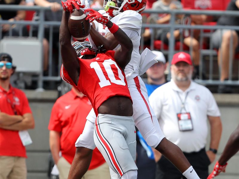 Sep 9, 2023; Columbus, Ohio, USA;  Ohio State Buckeyes cornerback Denzel Burke (10) intercepts the pass as Youngstown State Penguins wide receiver Bryce Oliver (0) attempts the catch during the second half at Ohio Stadium. Mandatory Credit: Joseph Maiorana-USA TODAY Sports