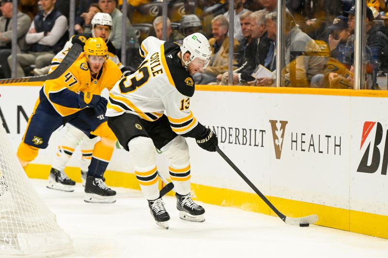 Oct 22, 2024; Nashville, Tennessee, USA;  Boston Bruins center Charlie Coyle (13) clears the puck against the Nashville Predators during the first period at Bridgestone Arena. Mandatory Credit: Steve Roberts-Imagn Images