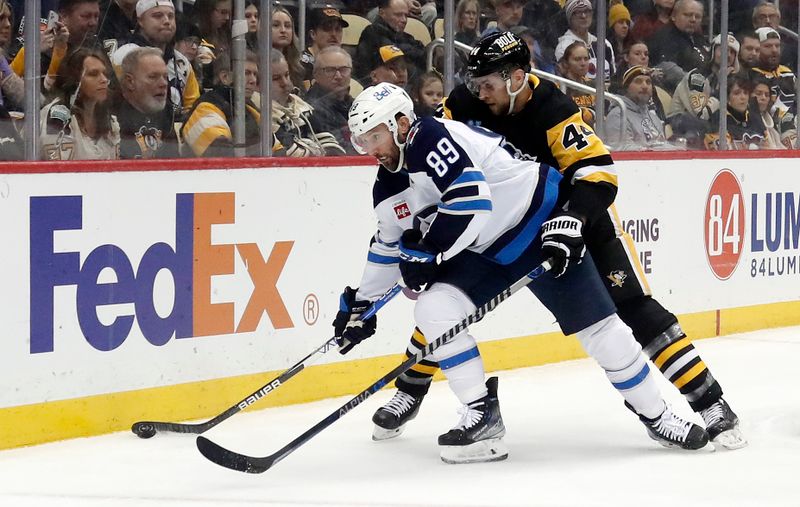 Jan 13, 2023; Pittsburgh, Pennsylvania, USA;  Winnipeg Jets center Sam Gagner (89) handles the puck against pressure from Pittsburgh Penguins defenseman Jan Rutta (44) during the first period at PPG Paints Arena. Mandatory Credit: Charles LeClaire-USA TODAY Sports