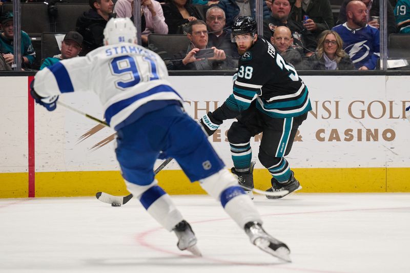 Mar 21, 2024; San Jose, California, USA; San Jose Sharks defenseman Mario Ferraro (38) plays the puck against Tampa Bay Lightning center Steven Stamkos (91) during the first period at SAP Center at San Jose. Mandatory Credit: Robert Edwards-USA TODAY Sports