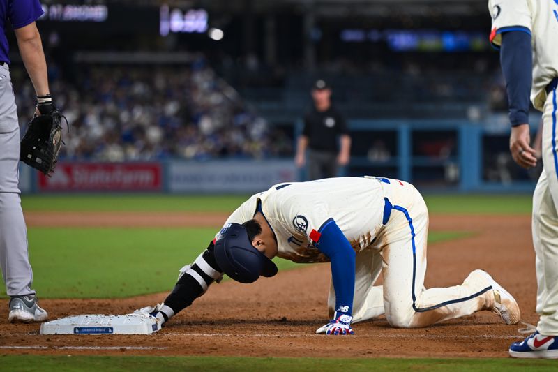 Sep 21, 2024; Los Angeles, California, USA; Los Angeles Dodgers designated hitter Shohei Ohtani (17) is safe at first base against Colorado Rockies first baseman Michael Toglia (4) during the ninth inning at Dodger Stadium. Mandatory Credit: Jonathan Hui-Imagn Images