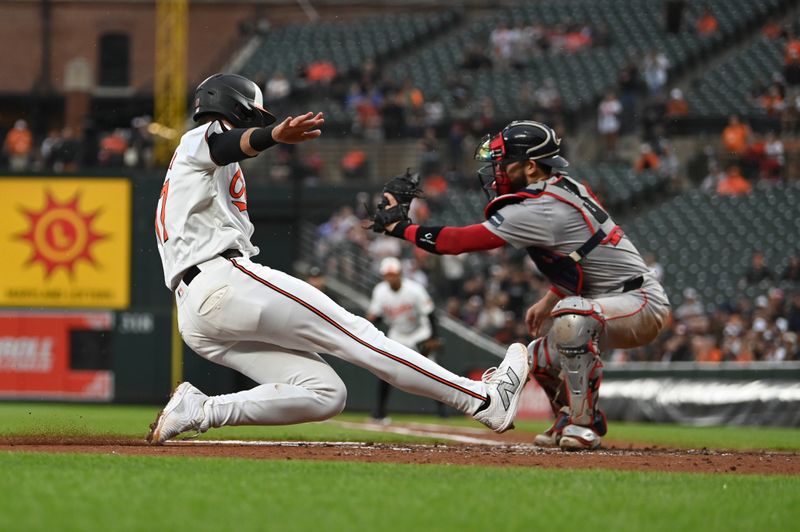 May 29, 2024; Baltimore, Maryland, USA; Baltimore Orioles outfielder Colton Cowser (17)   slides to score before Boston Red Sox catcher Connor Wong (12) can apply a tag during the second inning  at Oriole Park at Camden Yards. Mandatory Credit: Tommy Gilligan-USA TODAY Sports