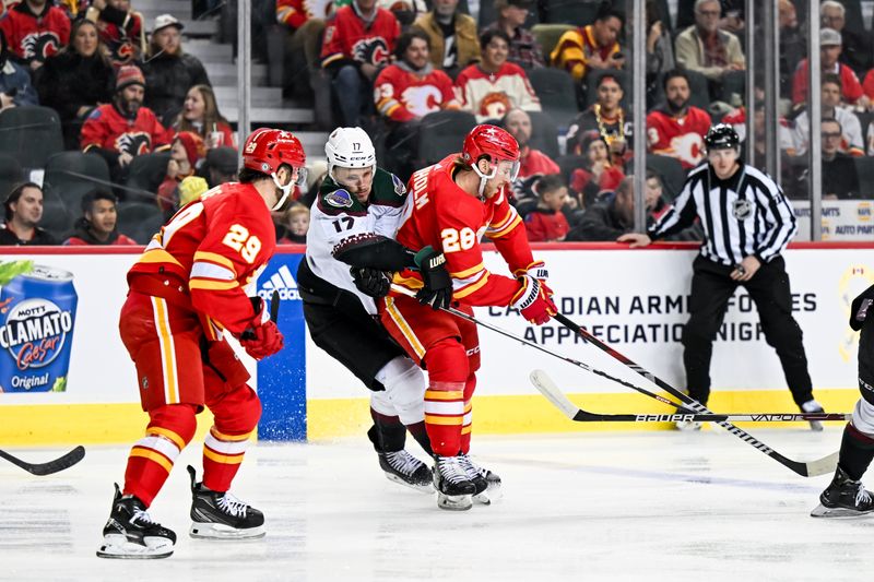 Jan 16, 2024; Calgary, Alberta, CAN; Arizona Coyotes center Nick Bjugstad (17) and Calgary Flames center Elias Lindholm (28) collide during the first period at Scotiabank Saddledome. Mandatory Credit: Brett Holmes-USA TODAY Sports