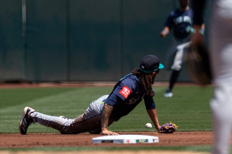 May 7, 2025; West Sacramento, California, USA; Seattle Mariners shortstop J.P. Crawford (3) dives in vain for a single off the bat of Athletics shortstop Jacob Wilson during the first inning at Sutter Health Park. Mandatory Credit: D. Ross Cameron-Imagn Images