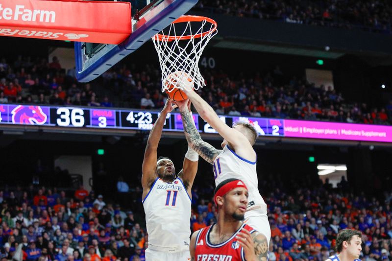 Feb 17, 2024; Boise, Idaho, USA; Boise State Broncos guard Chibuzo Agbo (11) and forward Cam Martin (31) go for a rebound during the first half against the Fresno Bulldogs at ExtraMile Arena. Mandatory Credit: Brian Losness-USA TODAY Sports

