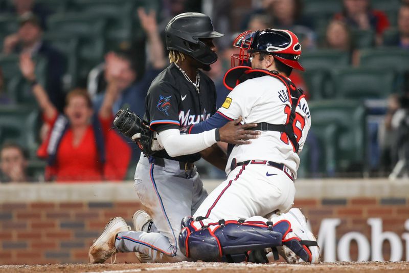 Apr 24, 2024; Atlanta, Georgia, USA; Atlanta Braves catcher Travis d'Arnaud (16) tags out Miami Marlins left fielder Nick Gordon (1) in the tenth inning at Truist Park. Mandatory Credit: Brett Davis-USA TODAY Sports