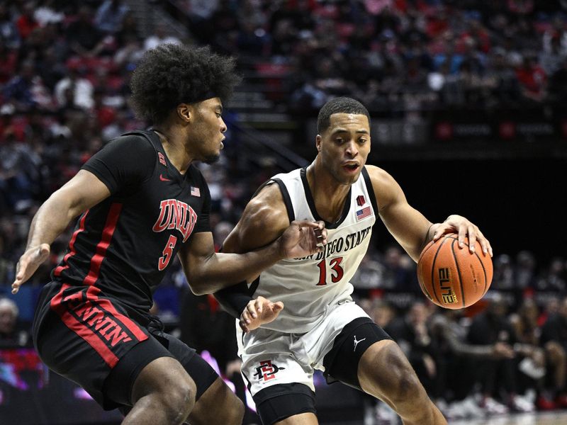 Jan 6, 2024; San Diego, California, USA; San Diego State Aztecs forward Jaedon LeDee (13) drives to the basket defended by UNLV Rebels forward Rob Whaley Jr. (5) during the second half at Viejas Arena. Mandatory Credit: Orlando Ramirez-USA TODAY Sports