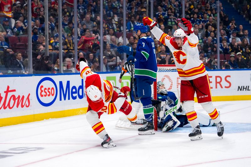 Oct 9, 2024; Vancouver, British Columbia, CAN; Vancouver Canucks goalie Arturs Silovs (31) and defenseman Carson Soucy (7) watch as Calgary Flames forward Martin Pospisil (76) and forward Jonathan Huberdeau (10) celebrate Huberdeau’s goal during the third period at Rogers Arena. Mandatory Credit: Bob Frid-Imagn Images