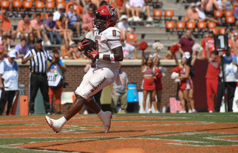 Sep 21, 2024; Clemson, South Carolina, USA; North Carolina State Wolfpack running back Kendrick Raphael (0) scores against Clemson Tigers during the third quarter at Memorial Stadium. Mandatory Credit: Ken Ruinard-Imagn Images