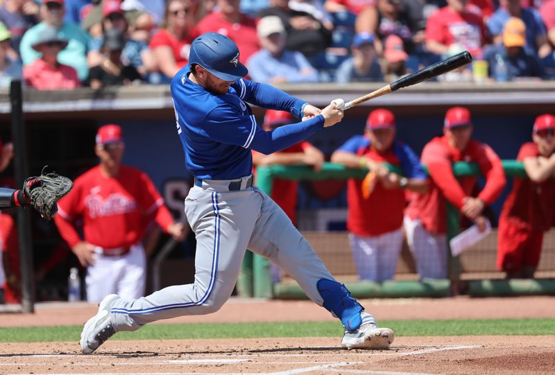 Mar 12, 2023; Clearwater, Florida, USA;  Toronto Blue Jays catcher Danny Jansen (9) singles against the Philadelphia Phillies during the second inning at BayCare Ballpark. Mandatory Credit: Kim Klement-USA TODAY Sports