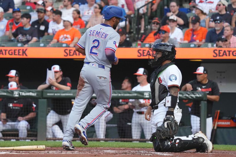 Jun 25, 2025; Baltimore, Maryland, USA; Texas Rangers second baseman Marcus Semien (right) scores during the second inning against the Baltimore Orioles at Oriole Park at Camden Yards. Mandatory Credit: Mitch Stringer-Imagn Images