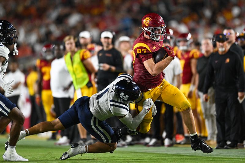 Sep 7, 2024; Los Angeles, California, USA; Utah State Aggies linebacker Jon Ross Maye (1) attempts to tackle USC Trojans tight end Lake McRee (87) during the second quarter at United Airlines Field at Los Angeles Memorial Coliseum. Mandatory Credit: Jonathan Hui-Imagn Images