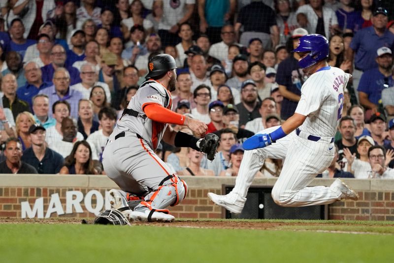 Jun 18, 2024; Chicago, Illinois, USA; San Francisco Giants catcher Curt Casali (18) tags out Chicago Cubs outfielder Seiya Suzuki (27) during the eighth inning at Wrigley Field. Mandatory Credit: David Banks-USA TODAY Sports