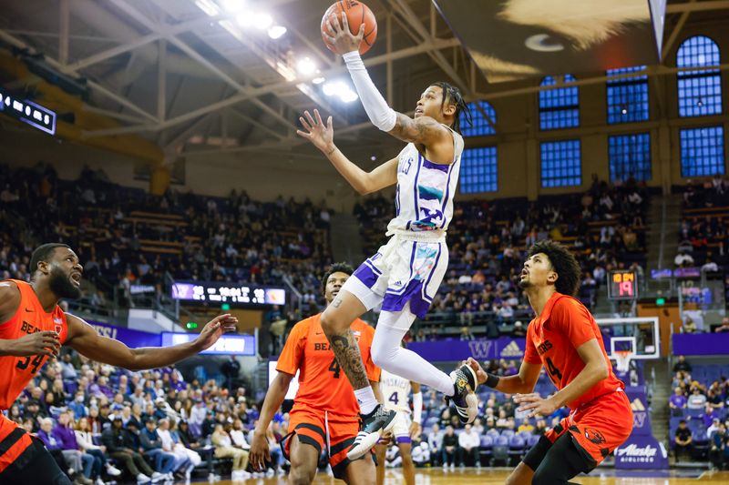 Feb 18, 2023; Seattle, Washington, USA; Washington Huskies guard Koren Johnson (0) jumps for a layup against Oregon State Beavers forward Rodrigue Andela (34), guard Dexter Akanno (4) and Oregon State Beavers forward Jayden Stevens (right) during the first half at Alaska Airlines Arena at Hec Edmundson Pavilion. Mandatory Credit: Joe Nicholson-USA TODAY Sports
