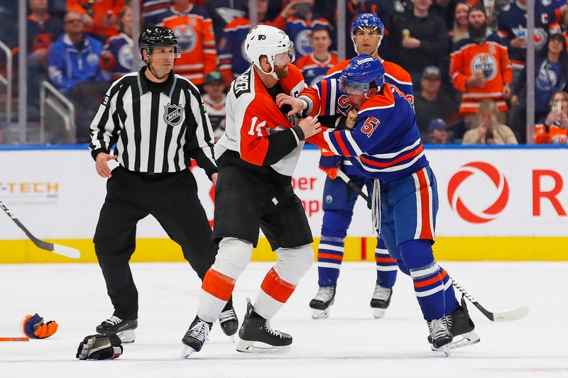Oct 15, 2024; Edmonton, Alberta, CAN; Edmonton Oilers defensemen Troy Stecher (51) and Philadelphia Flyers forward Sean Couturier (14) fight during the third period at Rogers Place. Mandatory Credit: Perry Nelson-Imagn Images