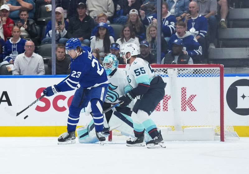 Oct 18, 2025; Toronto, Ontario, CAN; Toronto Maple Leafs left wing Matthew Knies (23) goes after the puck defended by Seattle Kraken defenseman Ryan Lindgren (55) during the second period at Scotiabank Arena. Mandatory Credit: Nick Turchiaro-Imagn Images