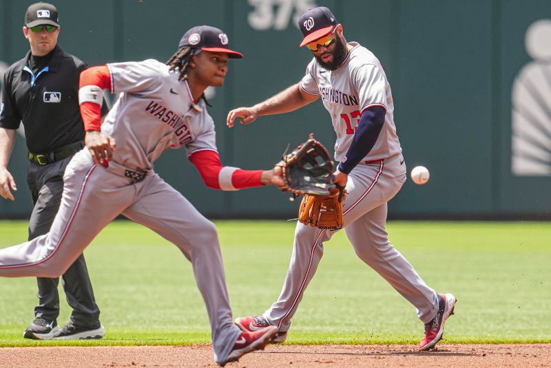 May 15, 2025; Cumberland, Georgia, USA; Washington Nationals shortstop CJ Abrams (5) and second baseman Amed Rosario (13) both go for a ground ball against the Atlanta Braves during the second inning at Truist Park. Mandatory Credit: Dale Zanine-Imagn Images