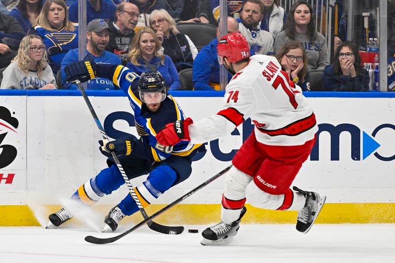 Apr 12, 2024; St. Louis, Missouri, USA;  St. Louis Blues left wing Brandon Saad (20) controls the puck against Carolina Hurricanes defenseman Jaccob Slavin (74) during the second period at Enterprise Center. Mandatory Credit: Jeff Curry-USA TODAY Sports