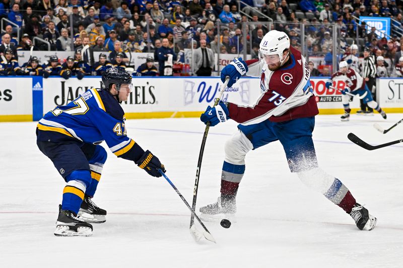 Mar 19, 2024; St. Louis, Missouri, USA;  Colorado Avalanche center Yakov Trenin (73) shoots as St. Louis Blues defenseman Torey Krug (47) defends during the third period at Enterprise Center. Mandatory Credit: Jeff Curry-USA TODAY Sports