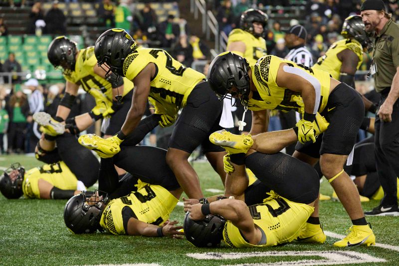 Nov 11, 2023; Eugene, Oregon, USA; Oregon Ducks running back Kilohana Haasenritter (29), right, stretches running back Jayden Limar (27) during warm ups before a game against the USC Trojans at Autzen Stadium. Mandatory Credit: Troy Wayrynen-USA TODAY Sports