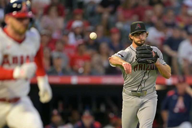 Jul 12, 2025; Anaheim, California, USA;  Arizona Diamondbacks starting pitcher Zac Gallen (23) throws Los Angeles Angels left fielder Taylor Ward (3) out at first base during the fifth inning at Angel Stadium. Mandatory Credit: Jayne Kamin-Oncea-Imagn Images