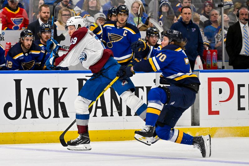 Dec 29, 2023; St. Louis, Missouri, USA;  St. Louis Blues center Oskar Sundqvist (70) checks Colorado Avalanche center Nathan MacKinnon (29) during the third period at Enterprise Center. Mandatory Credit: Jeff Curry-USA TODAY Sports