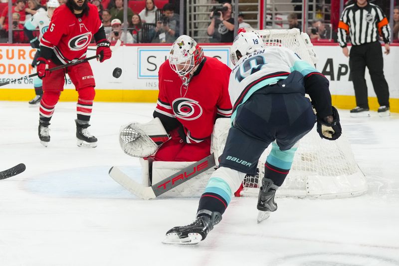 Jan 10, 2026; Raleigh, North Carolina, USA;  Carolina Hurricanes goaltender Brandon Bussi (32) stops the shot attempt by Seattle Kraken left wing Jared McCann (19) during the second period at Lenovo Center. Mandatory Credit: James Guillory-Imagn Images