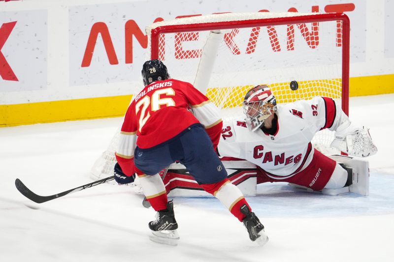 Nov 10, 2023; Sunrise, Florida, USA; Florida Panthers defenseman Uvis Balinskis (26) scores a goal past Carolina Hurricanes goaltender Antti Raanta (32) during the first period at Amerant Bank Arena. Mandatory Credit: Jasen Vinlove-USA TODAY Sports