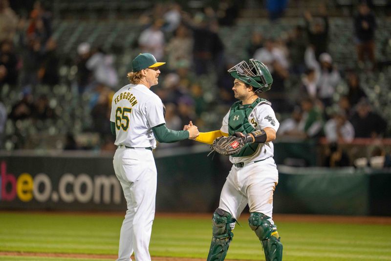 Aug 5, 2024; Oakland, California, USA;  Oakland Athletics pitcher Tyler Ferguson (65) and Oakland Athletics catcher Shea Langeliers (23) celebrate after the game against the Chicago White Sox at Oakland-Alameda County Coliseum. Mandatory Credit: Neville E. Guard-USA TODAY Sports