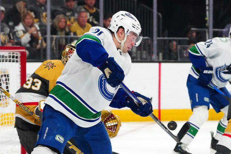 Mar 7, 2024; Las Vegas, Nevada, USA; Vancouver Canucks left wing Nils Hoglander (21) deflects the puck towards Vegas Golden Knights goaltender Adin Hill (33) during the first period at T-Mobile Arena. Mandatory Credit: Stephen R. Sylvanie-USA TODAY Sports