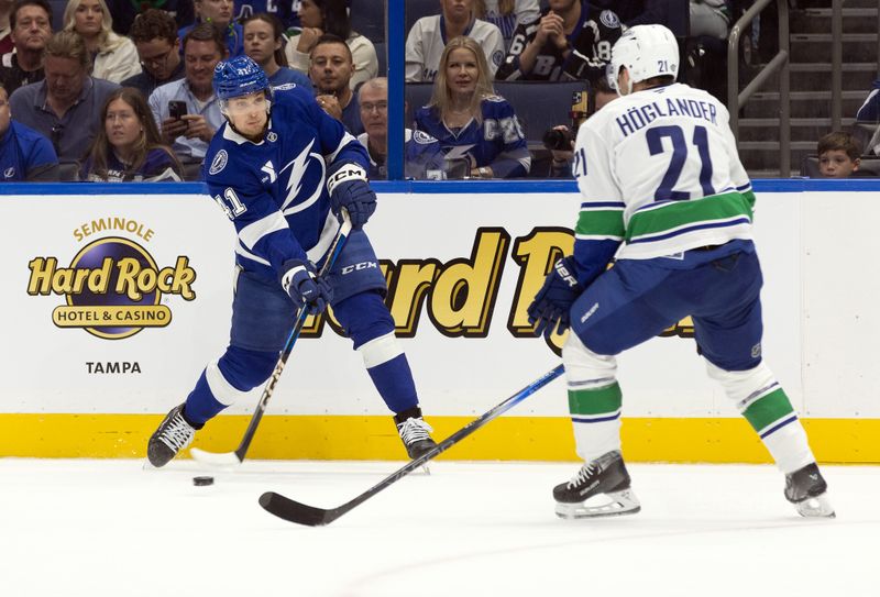 Oct 15, 2024; Tampa, Florida, USA; Tampa Bay Lightning right wing Mitchell Chaffee (41) shoots as Vancouver Canucks left wing Nils Hoglander (21) defends during the first period at Amalie Arena. Mandatory Credit: Kim Klement Neitzel-Imagn Images