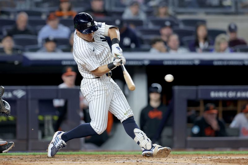 Sep 25, 2024; Bronx, New York, USA; New York Yankees shortstop Anthony Volpe (11) hits an RBI single against the Baltimore Orioles during the second inning at Yankee Stadium. Mandatory Credit: Brad Penner-Imagn Images