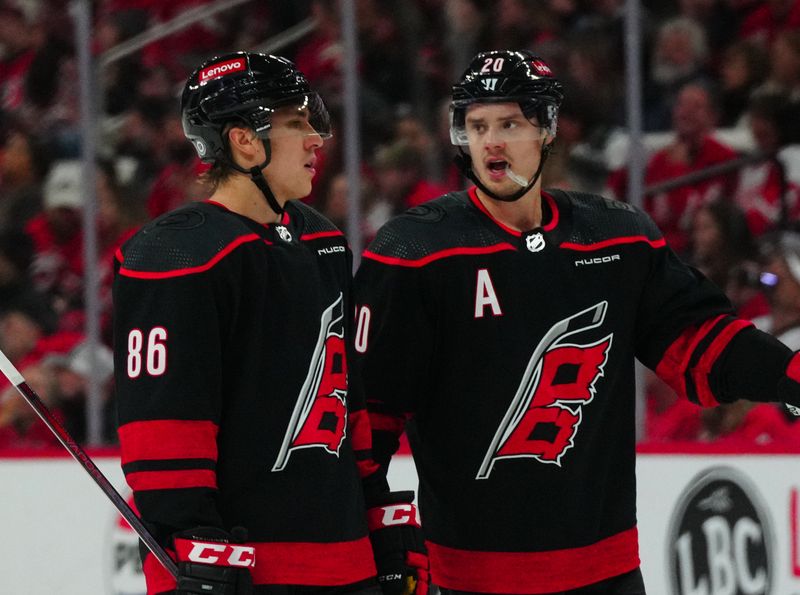 Jan 19, 2024; Raleigh, North Carolina, USA; Carolina Hurricanes center Sebastian Aho (20) and Carolina Hurricanes left wing Teuvo Teravainen (86) talk against the Detroit Red Wings during the first period at PNC Arena. Mandatory Credit: James Guillory-USA TODAY Sports