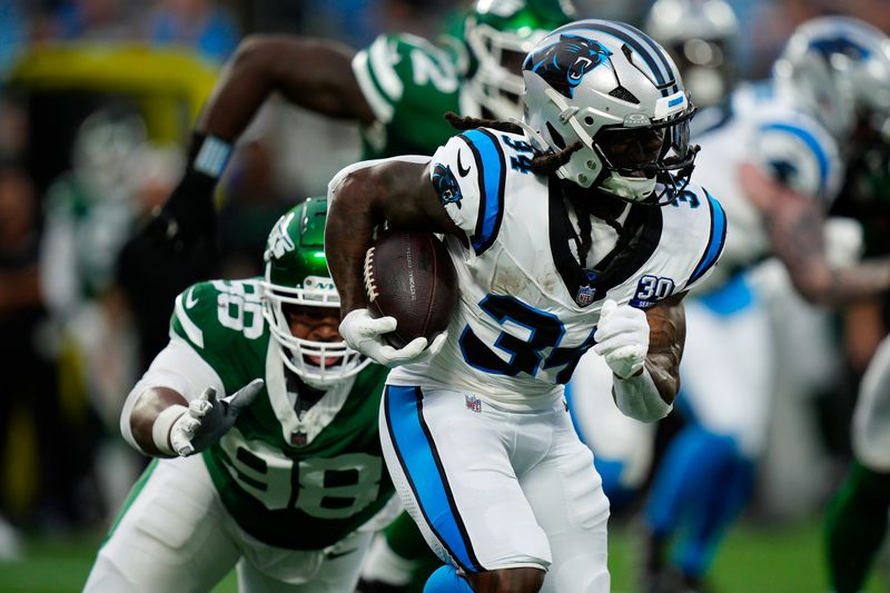 Carolina Panthers running back Mike Boone (34) runs against New York Jets defensive tackle Bruce Hector (98) during the first half of a preseason NFL football game, Saturday, Aug. 17, 2024, in Charlotte, N.C. (AP Photo/Jacob Kupferman)