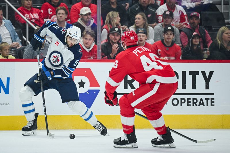 Oct 30, 2024; Detroit, Michigan, USA; Winnipeg Jets left wing Alex Iafallo (9) brings the puck up ice against Detroit Red Wings defenseman Jeff Petry (46) during the first period at Little Caesars Arena. Mandatory Credit: Tim Fuller-Imagn Images