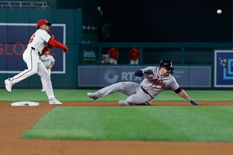 Sep 10, 2024; Washington, District of Columbia, USA; Washington Nationals second baseman Darren Baker (10) turns a double play at second base ahead of a slide by Atlanta Braves outfielder Adam Duvall (14) during the ninth inning at Nationals Park. Mandatory Credit: Geoff Burke-Imagn Images