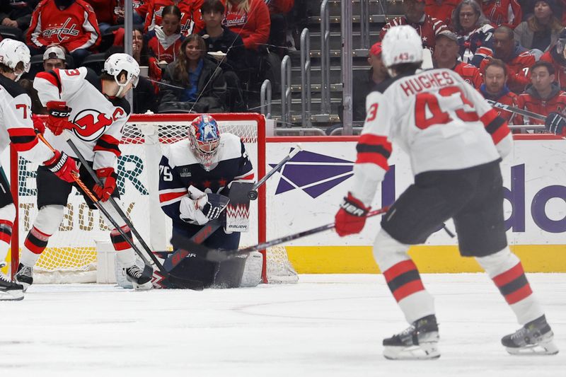 Feb 20, 2024; Washington, District of Columbia, USA; Washington Capitals goaltender Charlie Lindgren (79) makes a save on New Jersey Devils defenseman Luke Hughes (43) in the first period at Capital One Arena. Mandatory Credit: Geoff Burke-USA TODAY Sports