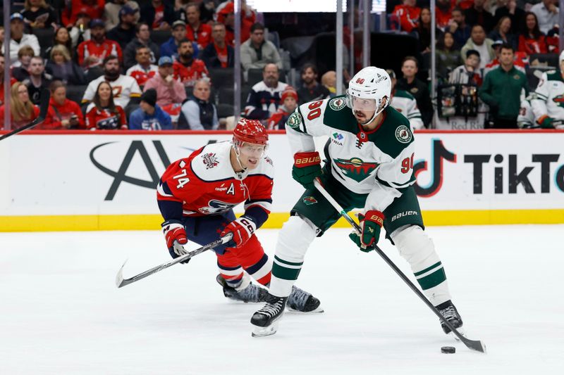 Oct 17, 2025; Washington, District of Columbia, USA; Minnesota Wild left wing Marcus Johansson (90) shoots the puck as Washington Capitals defenseman John Carlson (74) during the second period at Capital One Arena. Mandatory Credit: Geoff Burke-Imagn Images