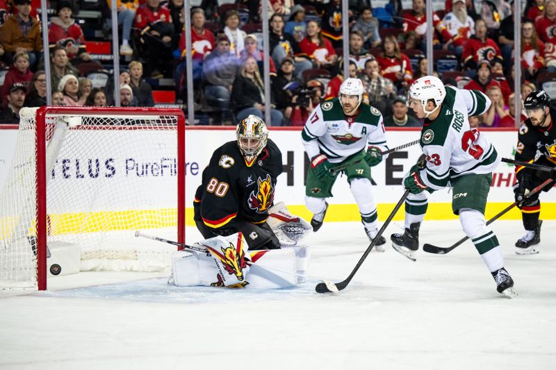 Nov 23, 2024; Calgary, Alberta, CAN; Minnesota Wild center Marco Rossi (23) scores a goal against Calgary Flames goaltender Daniel Vladar (80) during the third period at Scotiabank Saddledome. Mandatory Credit: Brett Holmes-Imagn Images