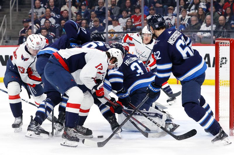 Mar 11, 2024; Winnipeg, Manitoba, CAN; Washington Capitals center Dylan Strome (17) and Winnipeg Jets right wing Nino Niederreiter (62) dig for the puck by Winnipeg Jets goaltender Connor Hellebuyck (37) in the first period at Canada Life Centre. Mandatory Credit: James Carey Lauder-USA TODAY Sports