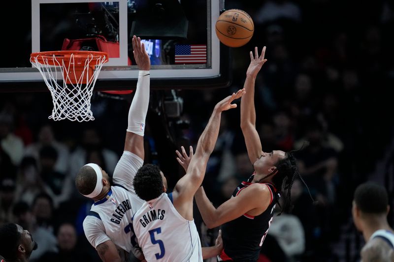 PORTLAND, OREGON - DECEMBER 01: Dalano Banton #5 of the Portland Trail Blazers shoots the ball over Daniel Gafford #21 and Quentin Grimes #5 of the Dallas Mavericks during the first half at Moda Center on December 01, 2024 in Portland, Oregon. NOTE TO USER: User expressly acknowledges and agrees that, by downloading and or using this photograph, User is consenting to the terms and conditions of the Getty Images License Agreement. (Photo by Soobum Im/Getty Images)