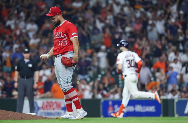 May 21, 2024; Houston, Texas, USA; Los Angeles Angels relief pitcher Luis Garcia (66) reacts and Houston Astros right fielder Kyle Tucker (30) rounds the bases after hitting a home run during the seventh inning at Minute Maid Park. Mandatory Credit: Troy Taormina-USA TODAY Sports