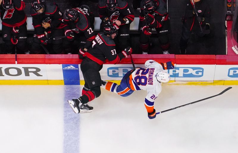 Apr 20, 2024; Raleigh, North Carolina, USA; Carolina Hurricanes right wing Andrei Svechnikov (37) checks New York Islanders defenseman Alexander Romanov (28) during the first period in game one of the first round of the 2024 Stanley Cup Playoffs at PNC Arena. Mandatory Credit: James Guillory-USA TODAY Sports